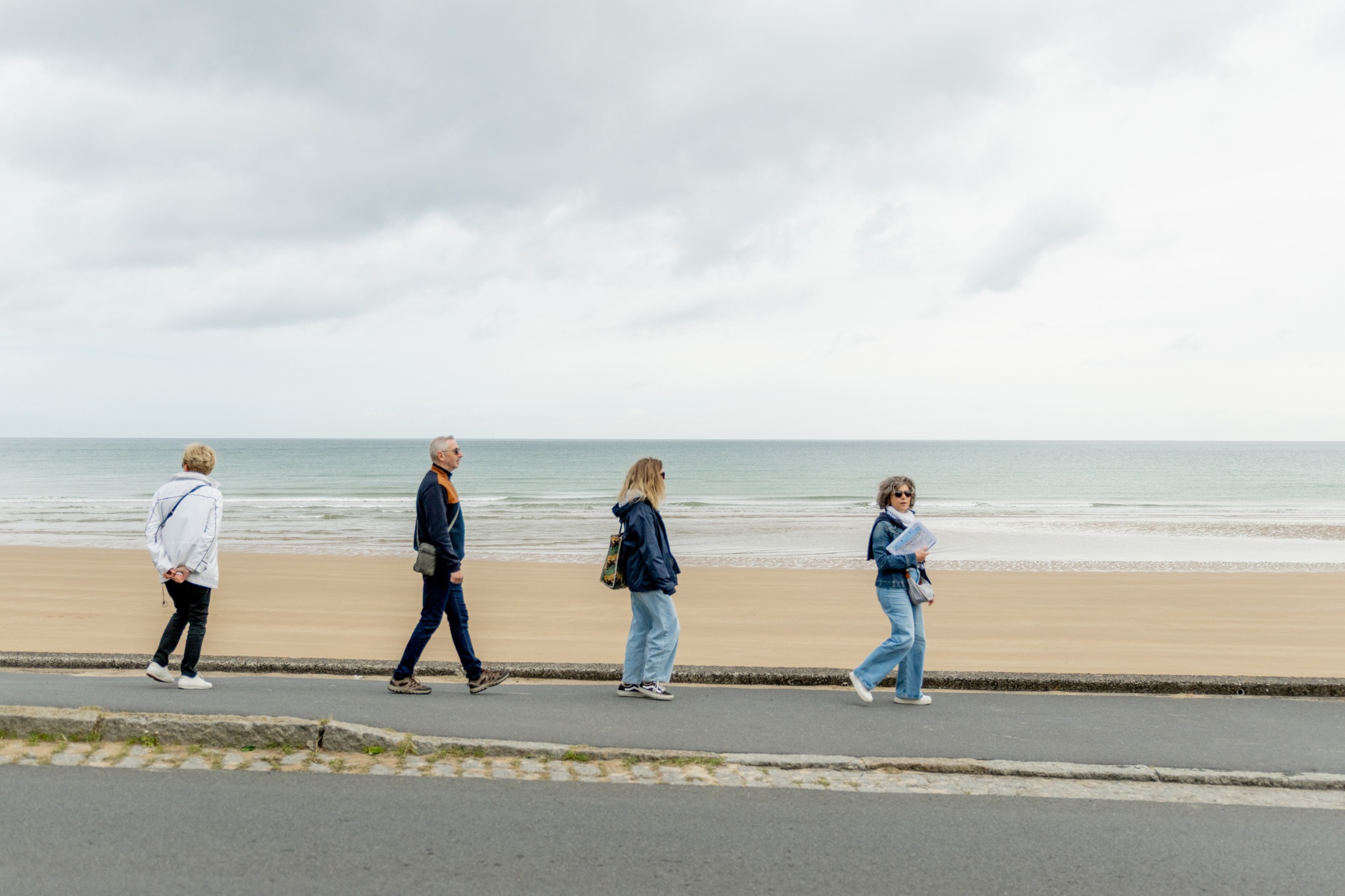 Small group walking along Omaha Beach during a guided Normandy tour.