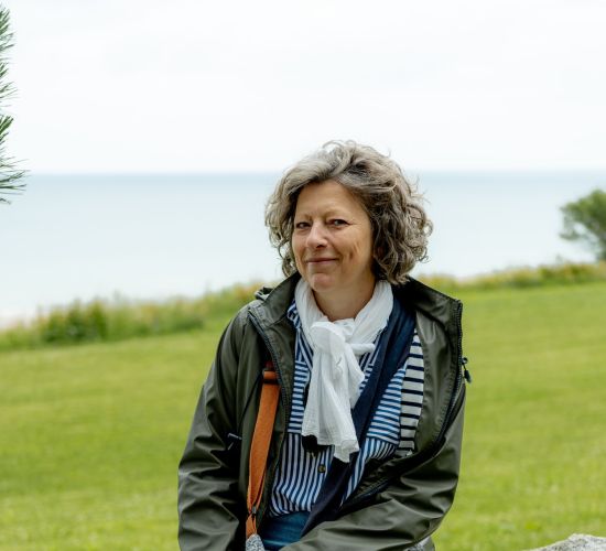 **Alt text:** *Portrait of a local Normandy guide at Omaha Beach, ready to lead visitors through the history of the D-Day landing sites.*