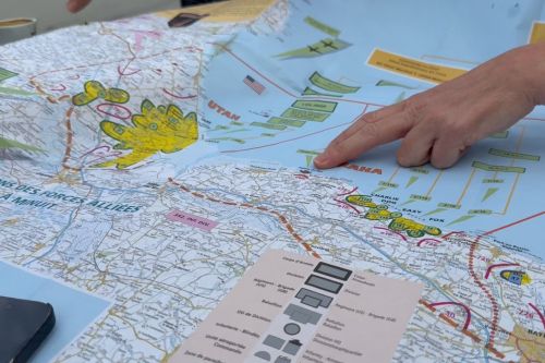 Guide explaining a detailed map of the D-Day landing beaches in Normandy.